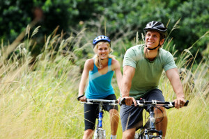 Happy couple riding bicycles outside, healthy lifestyle fun conc